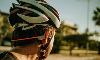 Atleta con casco usando audífonos Kivo Alba.