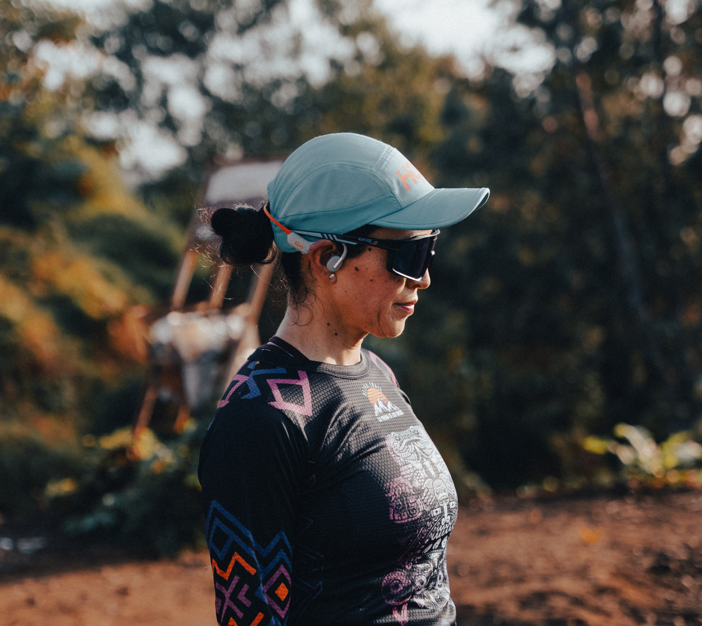Atleta con gorra y lentes deportivos usando audífonos Kivo Alba.
